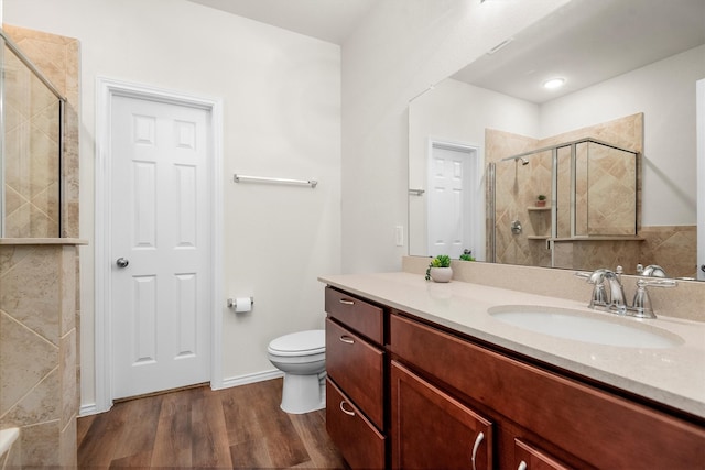 bathroom with vanity, toilet, hardwood / wood-style flooring, and an enclosed shower