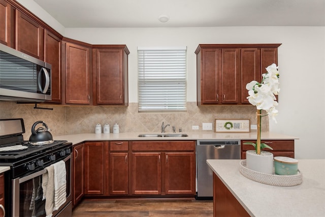 kitchen with tasteful backsplash, appliances with stainless steel finishes, sink, and dark hardwood / wood-style flooring