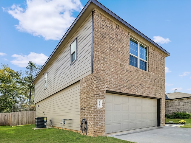 view of side of home with a garage, central air condition unit, and a lawn