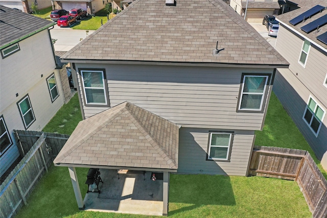 back of house with a patio and a lawn