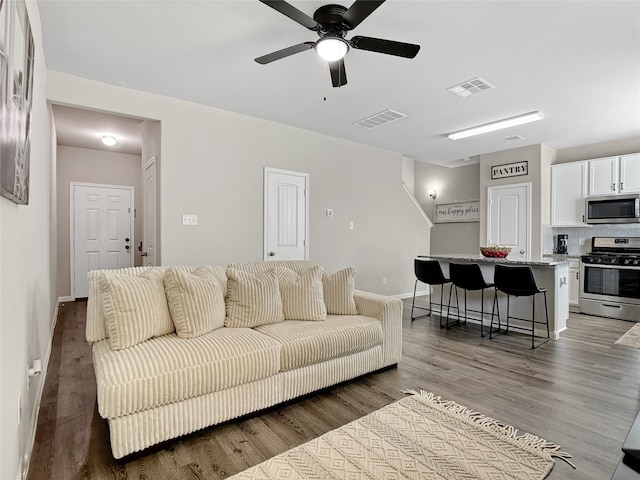 living room with dark hardwood / wood-style floors and ceiling fan