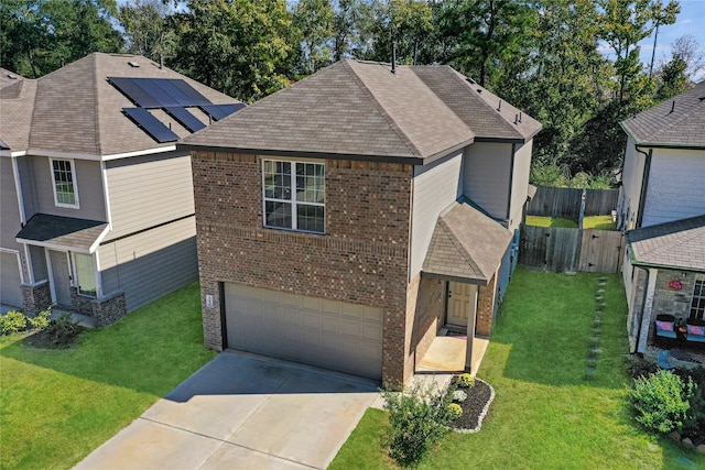 view of front facade with a front yard, solar panels, and a garage