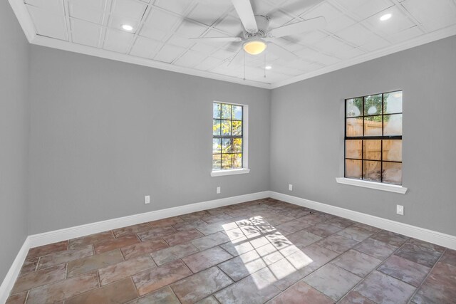 empty room featuring ceiling fan and crown molding