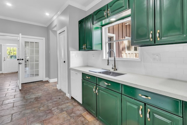 kitchen with backsplash, sink, white dishwasher, and green cabinetry