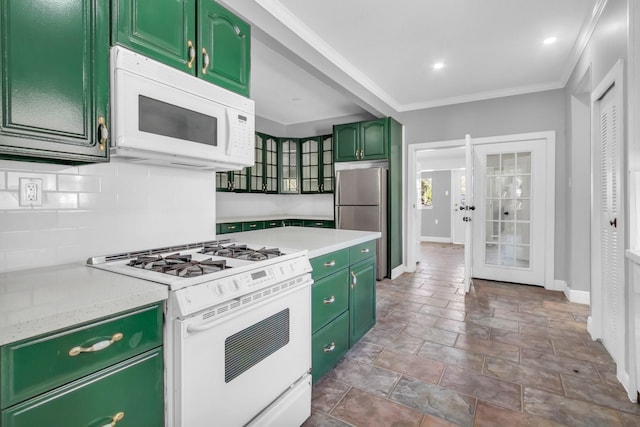 kitchen featuring white appliances, ornamental molding, green cabinets, and decorative backsplash