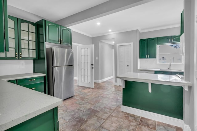 kitchen with crown molding, sink, stainless steel fridge, and green cabinets