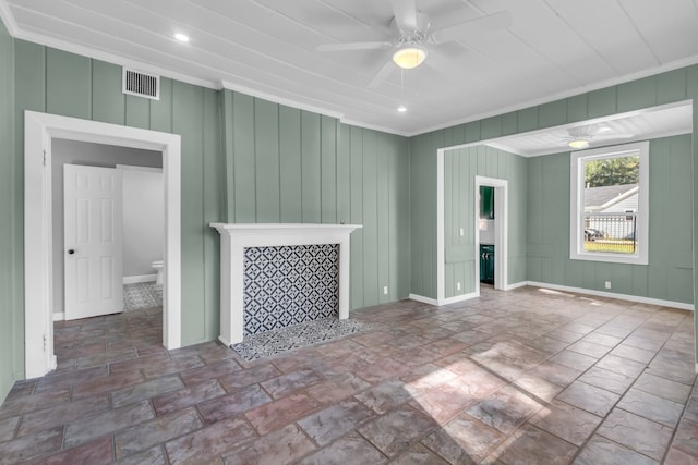 unfurnished living room with wooden walls, ceiling fan, and ornamental molding