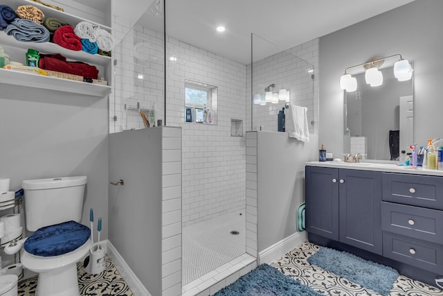 bathroom with toilet, tile patterned flooring, vanity, and tiled shower