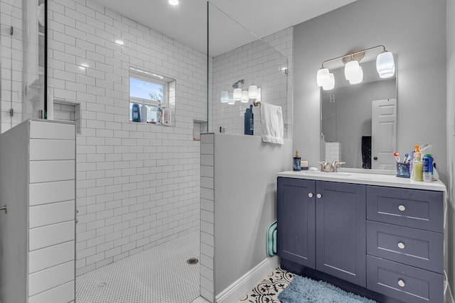 bathroom with a tile shower and vanity