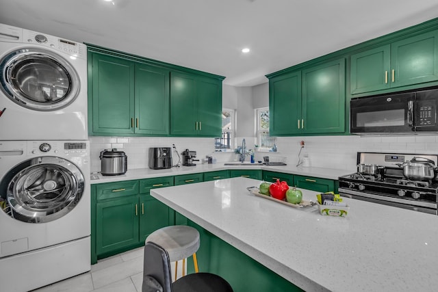 kitchen with backsplash, stacked washing maching and dryer, gas stove, sink, and light tile patterned flooring