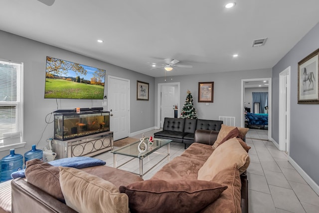 tiled living room with a fireplace and ceiling fan