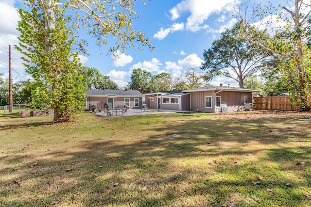 rear view of property featuring a patio and a lawn