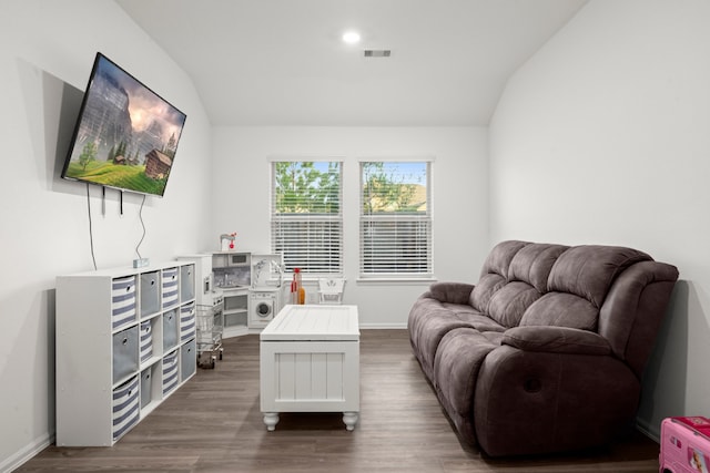 sitting room featuring dark wood-type flooring and vaulted ceiling