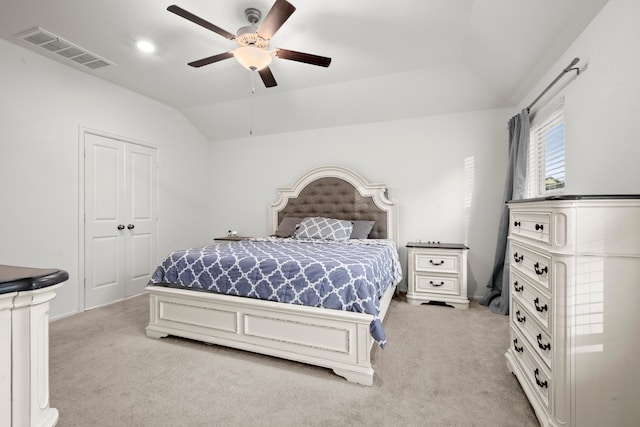 bedroom with a closet, lofted ceiling, light carpet, and ceiling fan