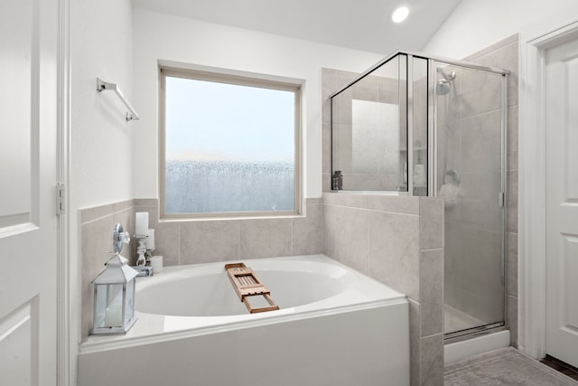 bathroom featuring plenty of natural light, shower with separate bathtub, and lofted ceiling