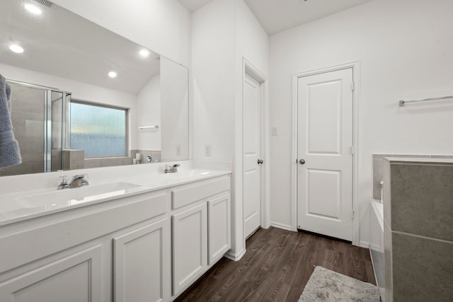 bathroom featuring wood-type flooring, vanity, and shower with separate bathtub