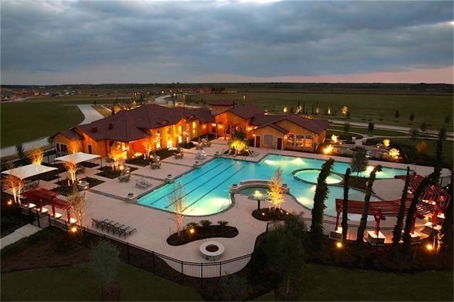 pool at dusk with a patio area