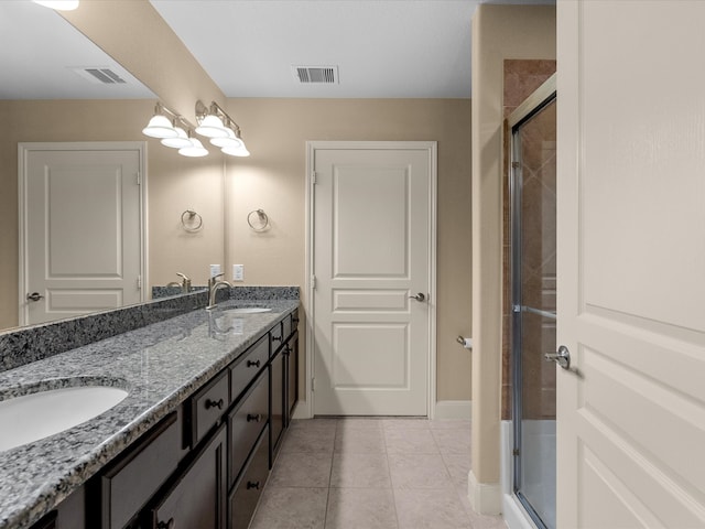 bathroom featuring tile patterned flooring, vanity, and a shower with shower door