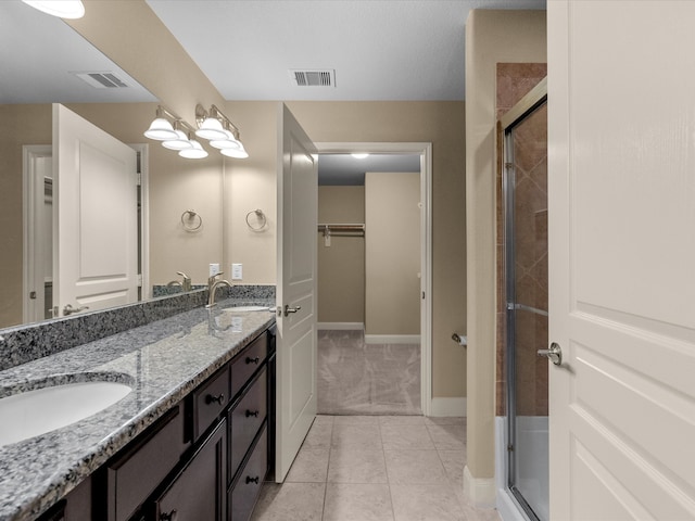 bathroom with tile patterned flooring, vanity, and an enclosed shower