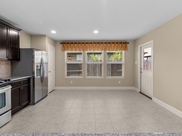 kitchen with stove, stainless steel refrigerator with ice dispenser, light tile patterned floors, tasteful backsplash, and dark brown cabinets