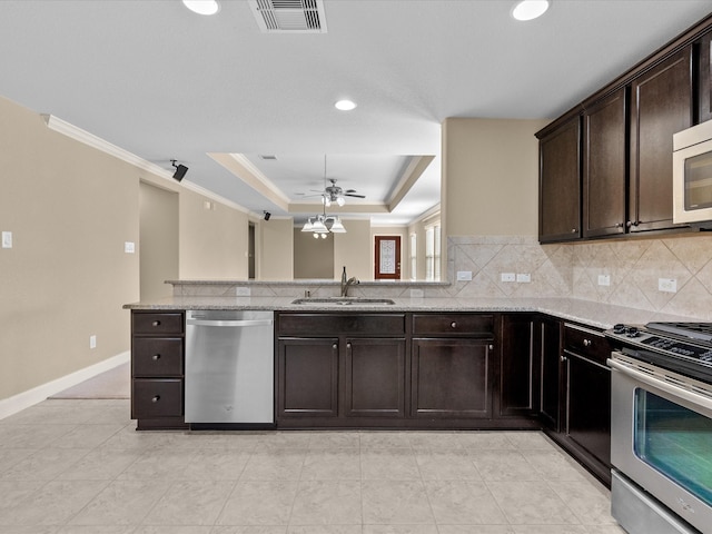 kitchen with tasteful backsplash, stainless steel appliances, a raised ceiling, ceiling fan, and sink