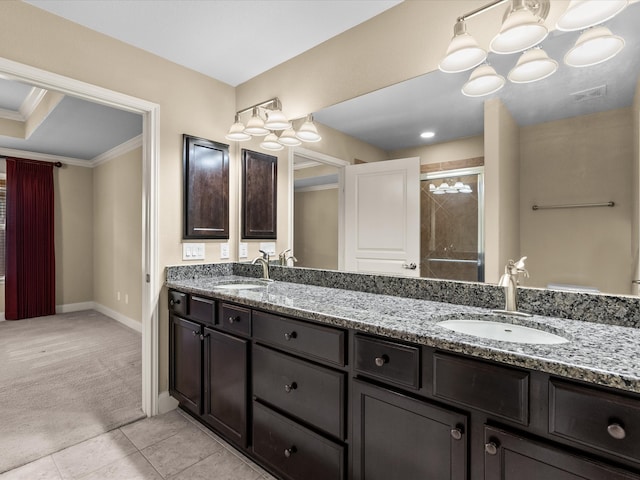 bathroom with tile patterned flooring, a shower with door, vanity, and ornamental molding