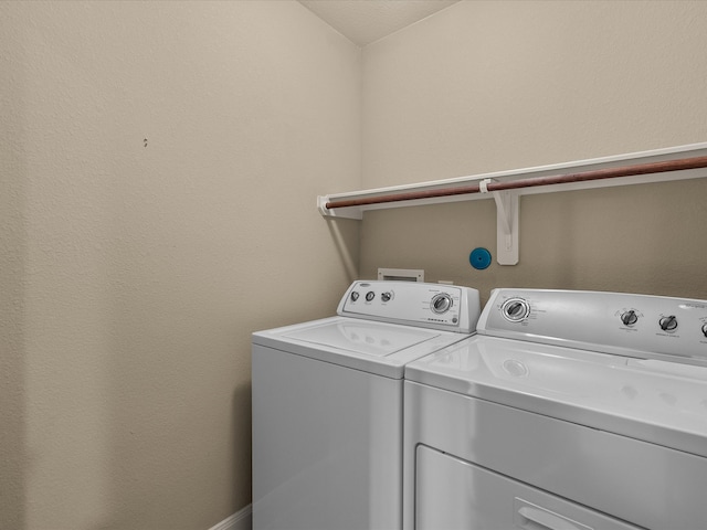 clothes washing area with washer and clothes dryer