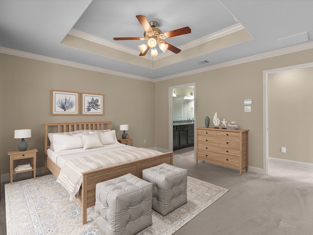 bedroom with light carpet, ensuite bathroom, a raised ceiling, and ceiling fan