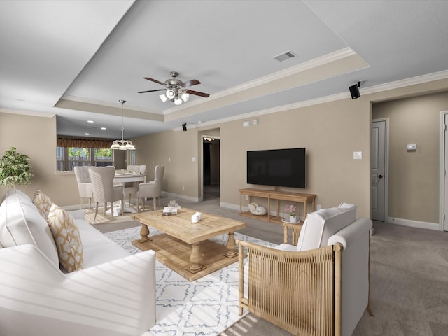 carpeted living room featuring ceiling fan, ornamental molding, and a tray ceiling