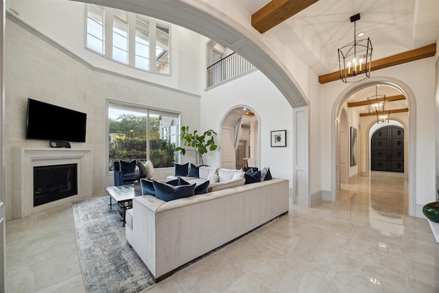 living room featuring high vaulted ceiling, beamed ceiling, and an inviting chandelier