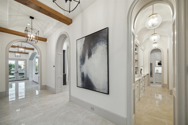 hallway with built in features, french doors, a notable chandelier, and vaulted ceiling with beams