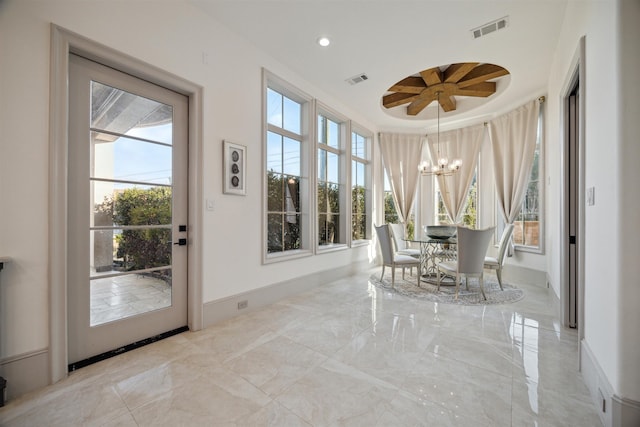 sunroom / solarium featuring an inviting chandelier