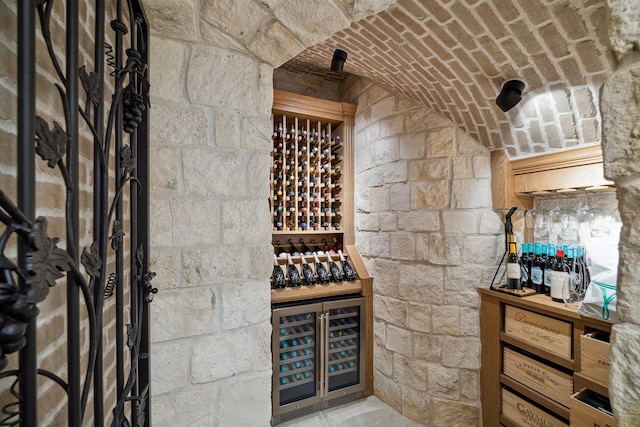 wine cellar featuring beverage cooler and brick ceiling