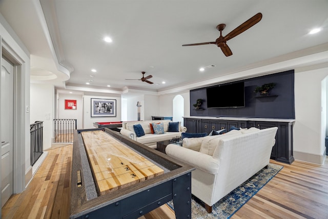 recreation room featuring ceiling fan, light wood-type flooring, and ornamental molding