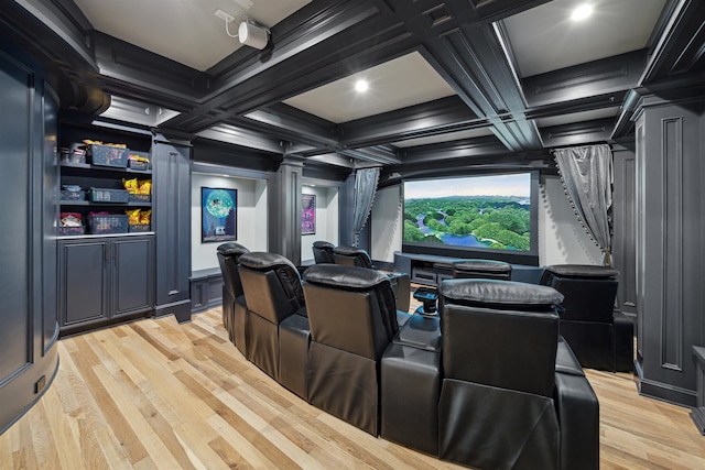 cinema with coffered ceiling, light hardwood / wood-style floors, ornate columns, and beam ceiling