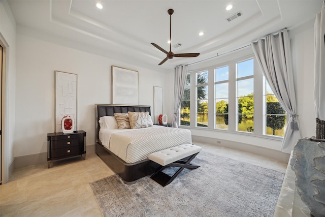 bedroom with ceiling fan and a raised ceiling