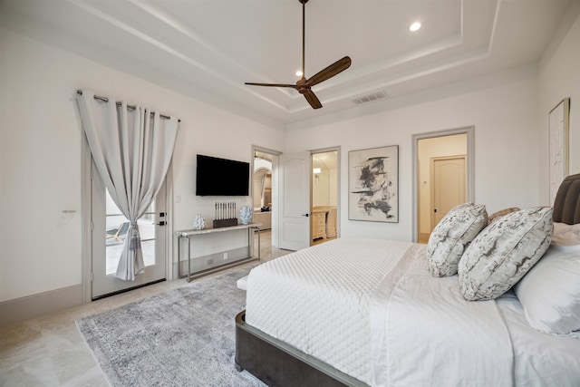 bedroom featuring ceiling fan, connected bathroom, and a raised ceiling