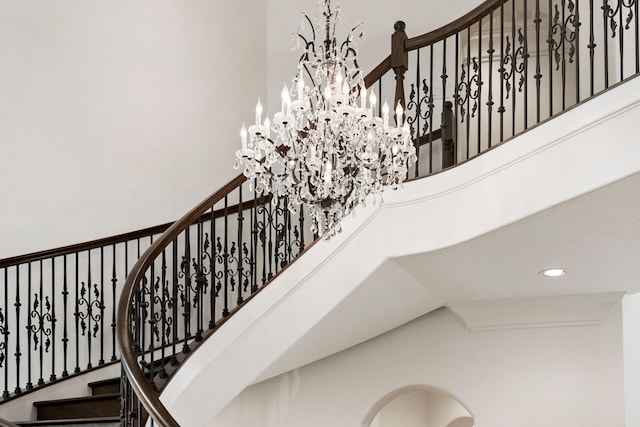 stairs with an inviting chandelier and a high ceiling