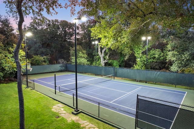 view of tennis court featuring a yard