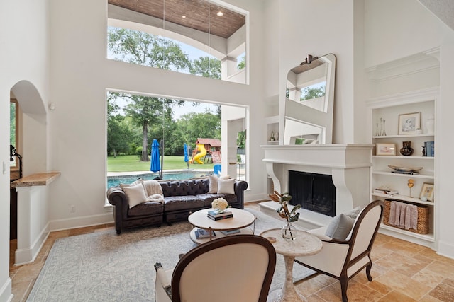 living room featuring a towering ceiling and built in shelves