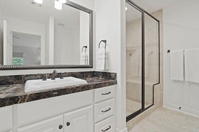 bathroom featuring vanity, a shower with shower door, and tile patterned flooring