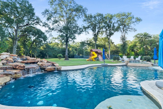 view of pool with a yard, pool water feature, and a playground