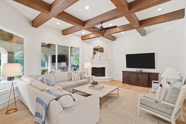 living room featuring beamed ceiling, coffered ceiling, light wood-type flooring, and a wealth of natural light