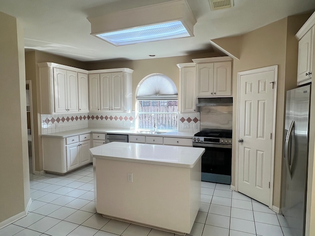 kitchen with white cabinetry, stainless steel appliances, sink, and a kitchen island