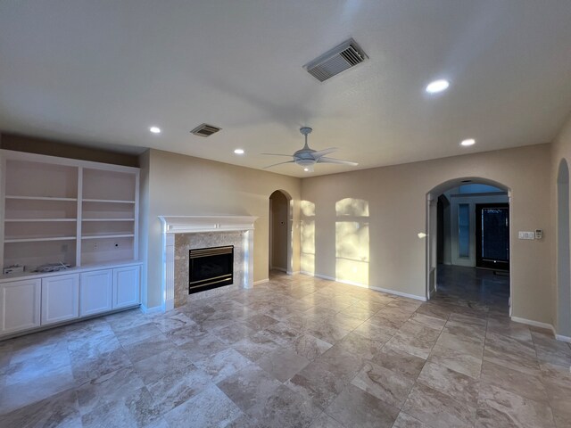 unfurnished living room featuring ceiling fan and a premium fireplace