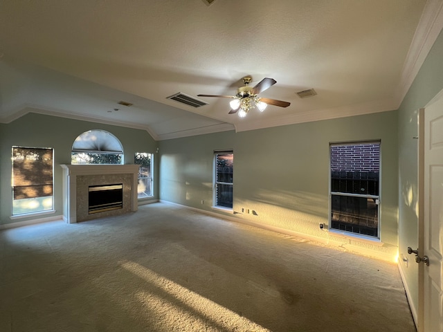 unfurnished living room with ceiling fan, ornamental molding, vaulted ceiling, and carpet