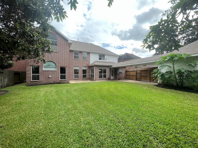 rear view of property featuring a lawn