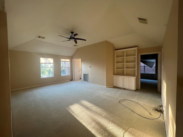 unfurnished living room with vaulted ceiling, ceiling fan, and carpet