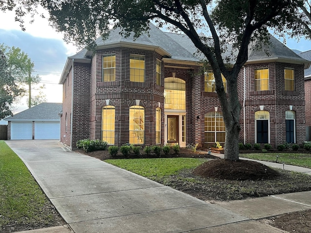 view of front facade featuring a garage, an outdoor structure, and a front lawn