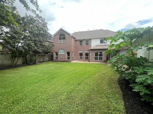 rear view of property with a patio and a yard